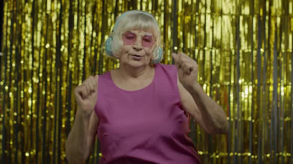 Senior Old Woman Dances, Listens Music on Headphones. Relaxing, Enjoying, Having Fun, Smiling alt