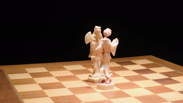 Tracking motion King and Queen ivory pieces on Chessboard, Black Background alt