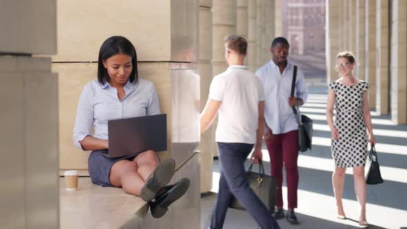 African Cheerful Businesswoman Working on Laptop Drink Coffee Outside alt
