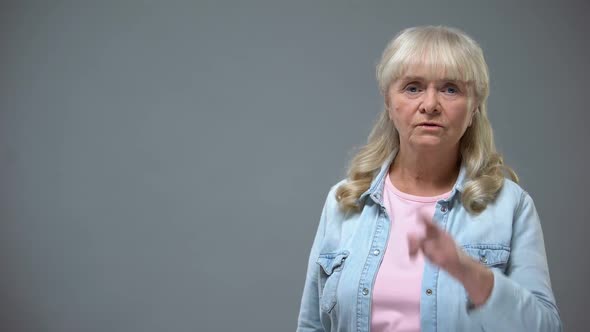 Unhappy Elderly Female Showing Quiet Gesture at Camera, Shame Concept, Prejudice alt