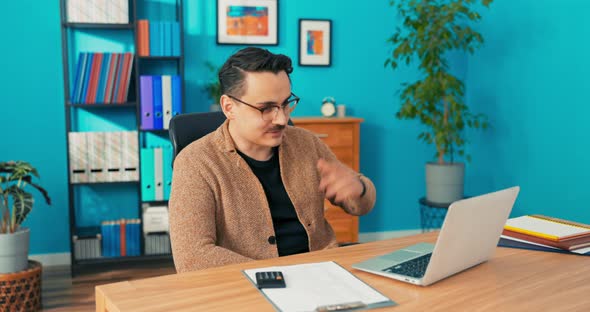 Video Call Via Webcam in Company Office Man with Glasses Sits Behind Desk in Front alt