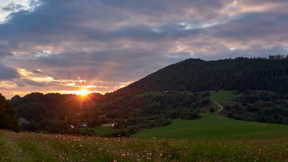 Sunset Over the Hills on a Green Meadow at Countryside in Summer  FHD Timelapse