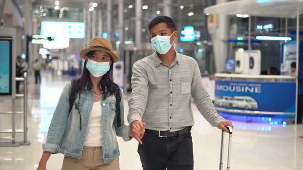 Couple Asian people walking in airport terminal waiting for  flight boarding