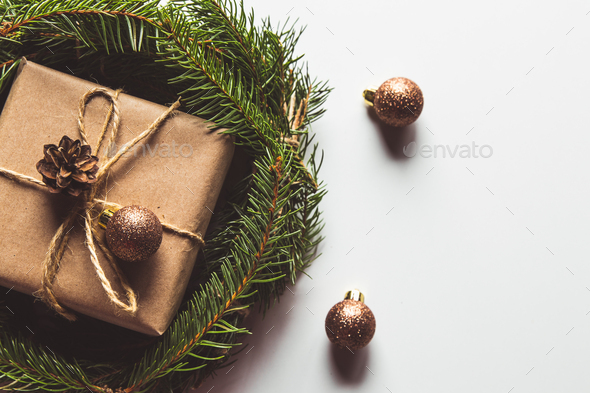 Gift in craft paper in a wreath of Christmas trees. Christmas mood, New Year, On white background - Stock Photo - Images