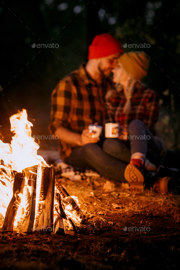 Young couple a guy and a girl in bright knitted hats stopped at a camping