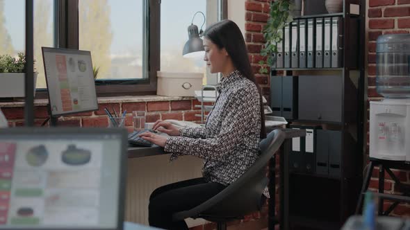 Asian Business Woman Using Computer to Work on Project alt