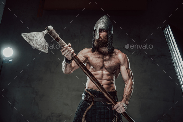 Viking with naked torso and beard posing in dark background Stock Photo ...