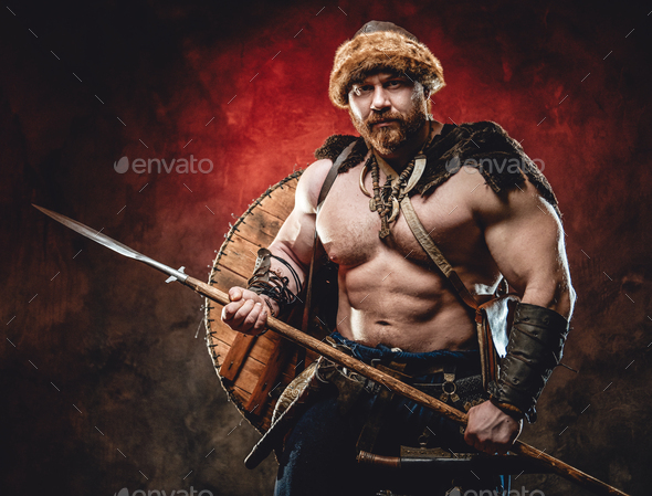 Strong and shirtless viking with spear in dark red background Stock ...