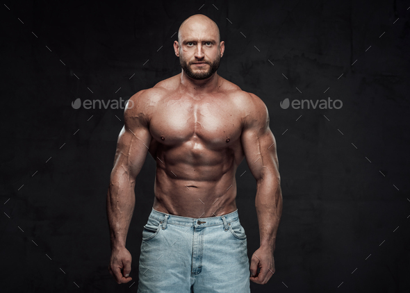 young handsome sportsman bodybuilder posing in jeans on grey background  Stock Photo | Adobe Stock