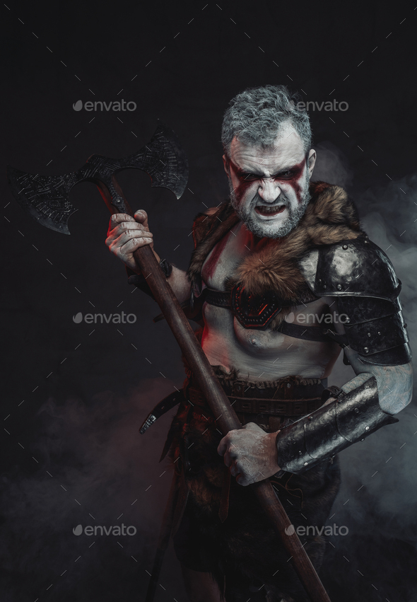 Savage warrior from the past with axe in atmospheric background Stock ...