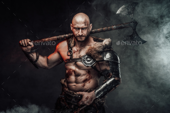 Violent topless viking holding huge axe on his shoulder in smokey ...