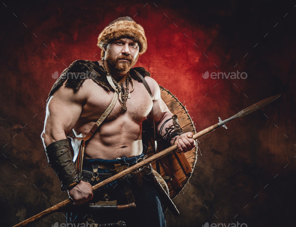 Handsome northern barbarian with spear in dark red background Stock ...