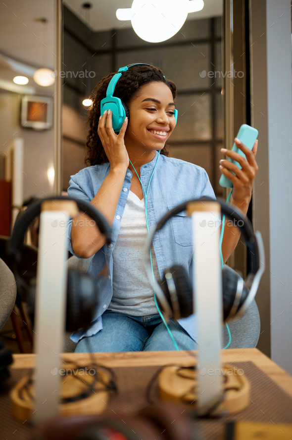 Woman listening to music in headphones store