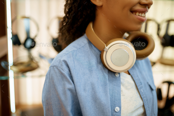 Young woman buying headphones in acoustics store