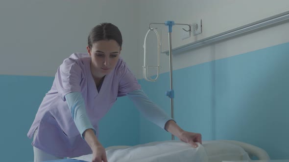 Expert nurse making the bed at the hospital