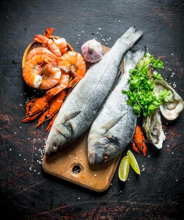 Fresh fish on a cutting Board with oysters, shrimp and crayfish.