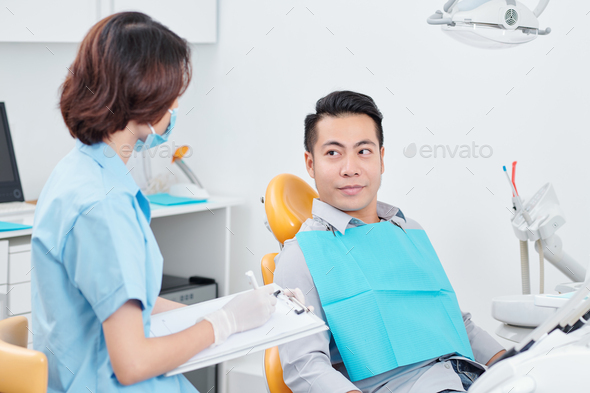 Nurse talking to patient in dental chair