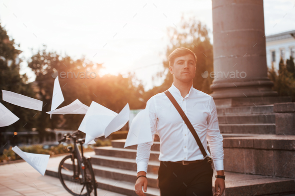 Leaving the project behind. Businessman in formal clothes with black bicycle is in the city