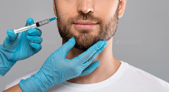 Unrecognizable bearded man getting lips filler in beauty salon, panorama