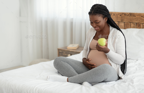 Healthy Pregnancy Diet. Pregnant African Woman Eating Apple While