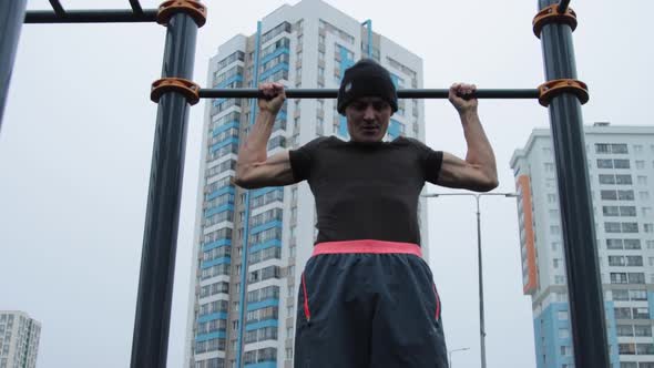 Muscular man training outdoors on sports field