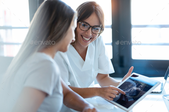 Gynecologist doctor showing to pregnant ultrasound scan baby with digital tablet in consultation. - Stock Photo - Images
