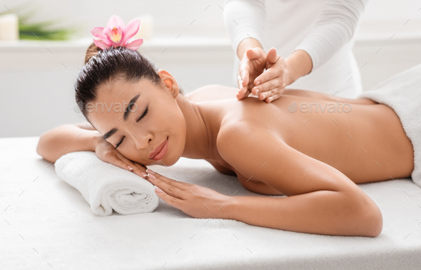 Woman getting classical back and neck massage Stock Photo by