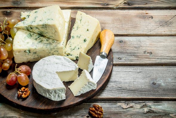 Blue and brie cheese with grapes on the Board. Stock Photo by Artem_ka2