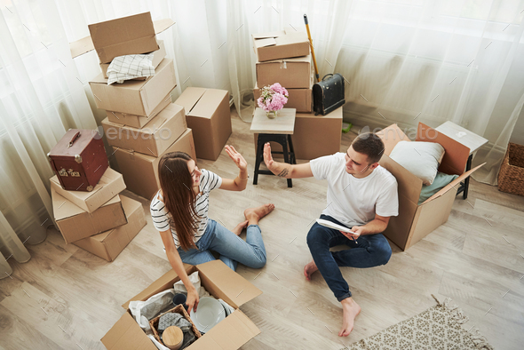Nice job, it\'s ours now. Cheerful young couple in their new apartment. Conception of moving