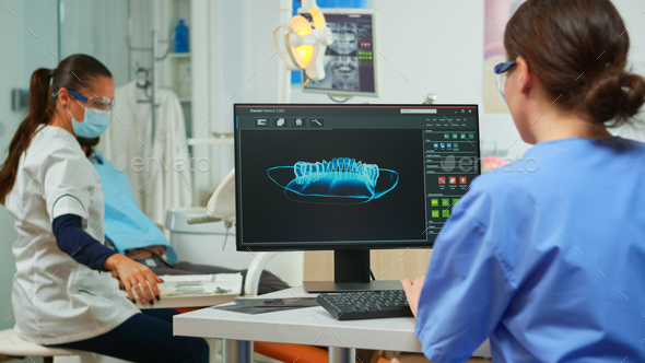 Dentist assistant writing parameters from digital dental fingerprint - Stock Photo - Images