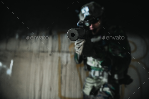 Soldier in full US MARSOC armed with assault rifle run through the abandoned building. Military