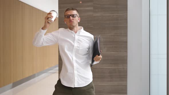Funny Businessman With Coffee Cup Dancing In Wireless Airpods In Office Hall alt