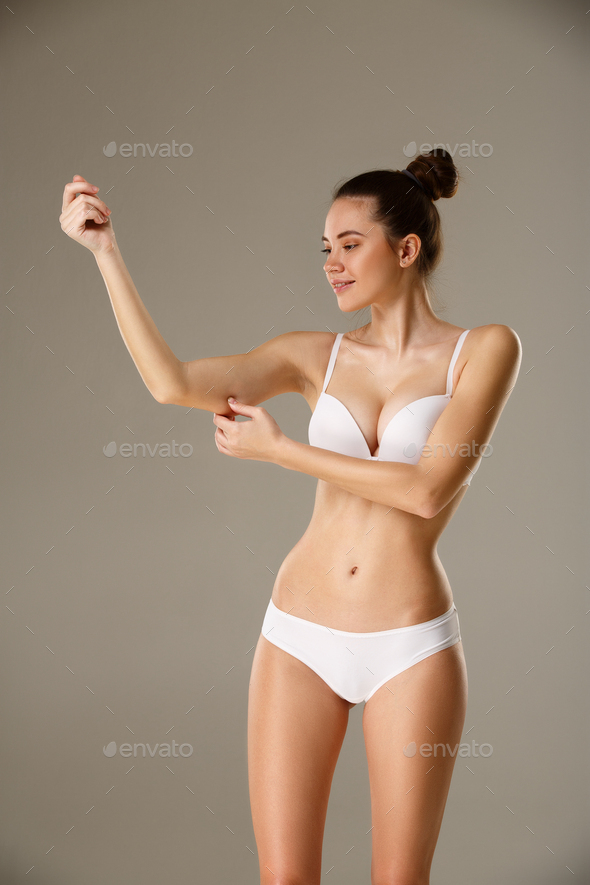 Woman pinching skin on her hand checking subcutaneous body fat