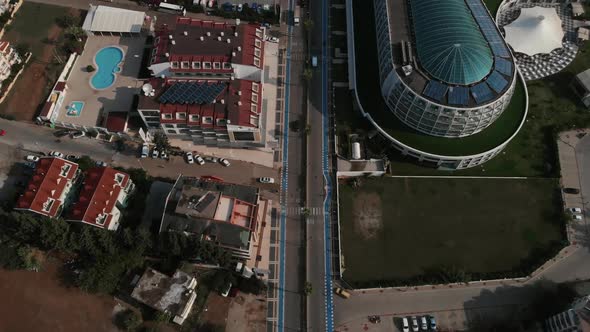 The Camera Flies Over the Roadway in the Resort Town. Along the Road There Are Hotels and Behind alt