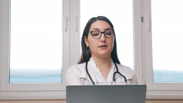 Woman Consults Patient Via Videocall on Laptop in Office alt