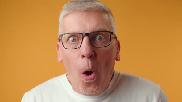 Middle Age Handsome Surprised Man Taking Off the Glasses