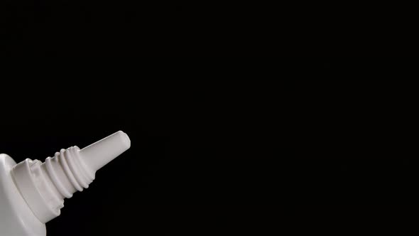 Spraying Liquid From a Vial of Medicine for the Nose on a Black Background. Prevention of COVID 19 alt