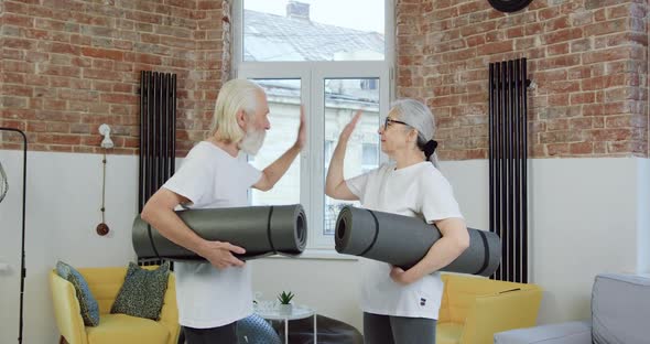 Senior Couple in Sportswear Giving High Five Each other Before Start to do exercises alt