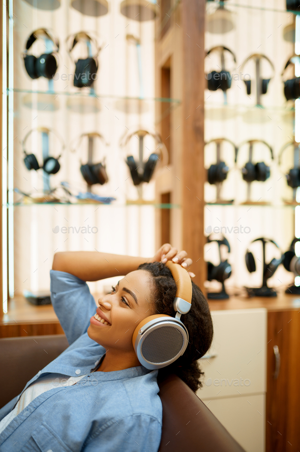 Happy woman listening to music, headphones store