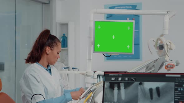 Woman Working As Dentist with Green Screen and x Ray Scan alt