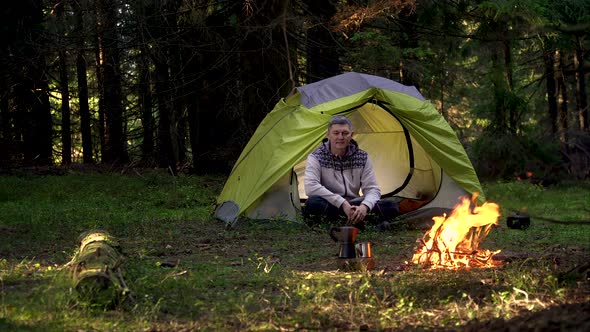 A Man Near a Fire in the Forest alt