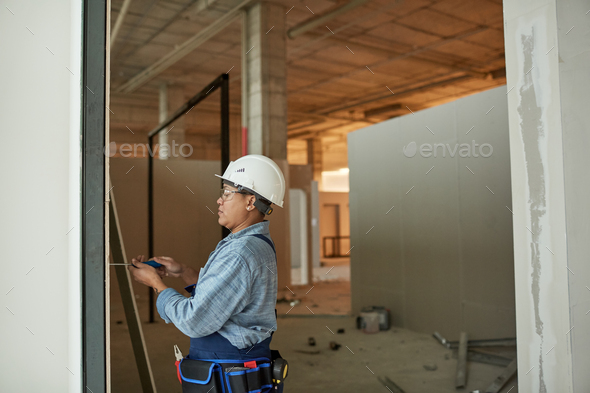 Mixed-Race Female Worker Building Wall