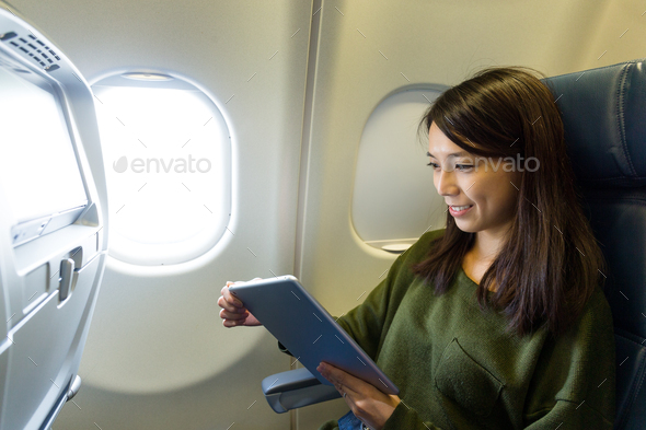 Woman use of digital tablet pc inside aircraft