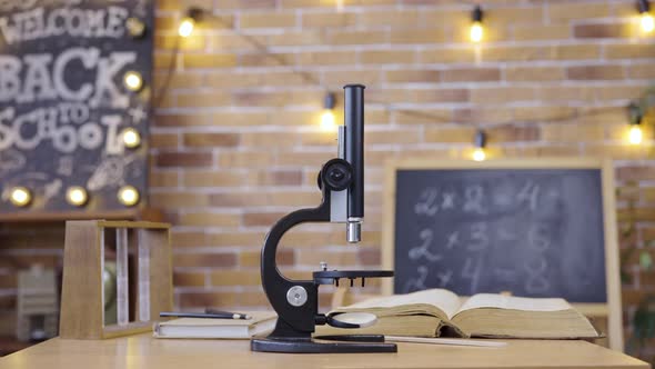 Empty Classroom with Chalkboard Desk Microscope and Textbook alt