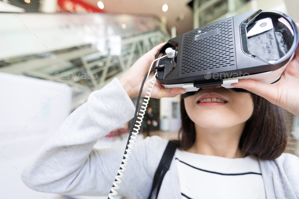 Woman trying on virtual reality device in shopping mall
