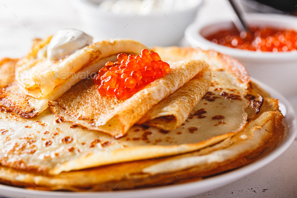 Stack of russian pancakes blini with red caviar, fresh sour cream - Stock Photo - Images