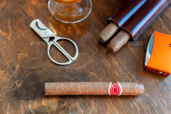 Cuban cigar and smoking accessories on wooden desk