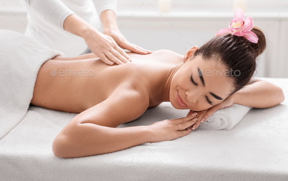 Woman getting classical back and neck massage Stock Photo by Prostock-studio