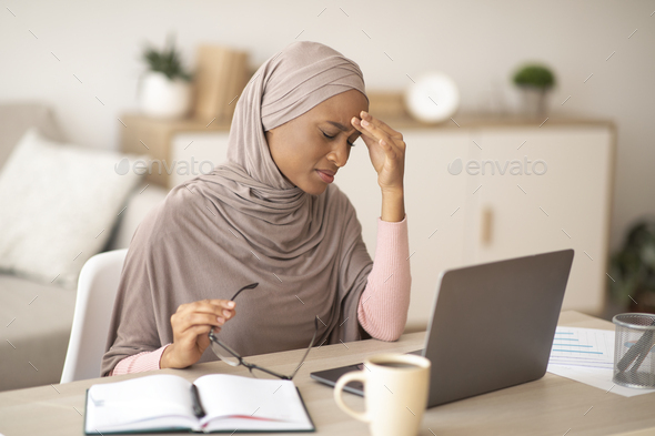 Deadline stress. Exhausted black woman in hijab tired after working on laptop for too long, having