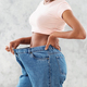 Unrecognizable black woman in oversized jeans showing results of